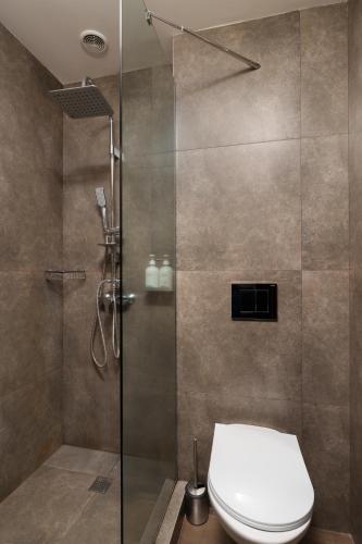 a shower stall with a toilet in a bathroom at Elysium Gallery Hotel in Yerevan