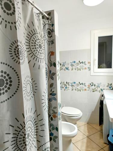 a bathroom with a toilet and a shower curtain at Il Posto Giusto tra cielo e mare in Pantelleria