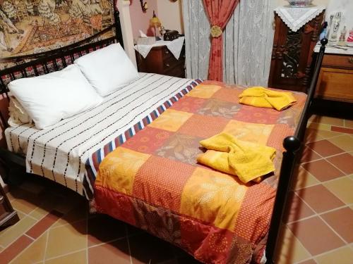 a bed with yellow towels on it in a room at Δάσος ΜΕ ΠΛΑΤΑΝΙΑ in Agios Dimitrios