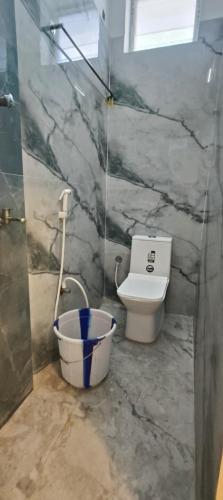 a bathroom with a toilet and a bucket at RVS Residency in Kāyalpattinam