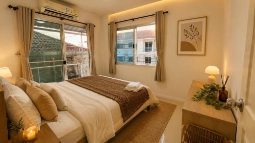a bedroom with a bed and a window at City Hill Residence in Ban Khok Chang