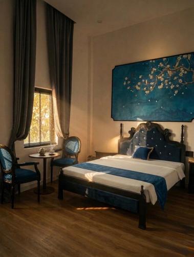 a bedroom with a bed with a large painting on the wall at LV Homestay in Nha Trang
