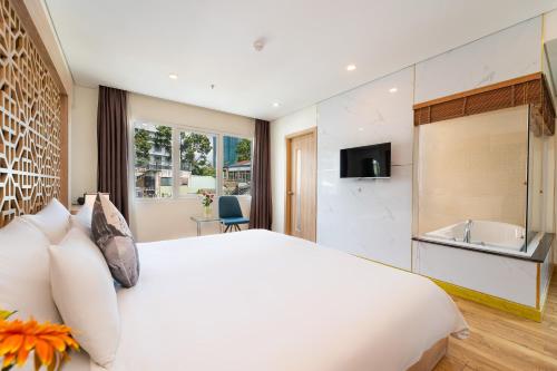 a bedroom with a large white bed and a bathroom at Gemini Saigon LUXURY in Ho Chi Minh City