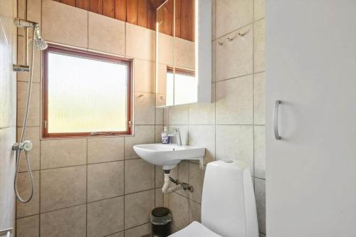 a bathroom with a toilet and a sink and a window at 8256-Vordingborg-Kastaniegardsvej-4 in Vordingborg