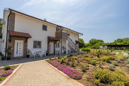 ein Garten vor einem Haus mit Blumen in der Unterkunft Mariachi Surčin in Surčin