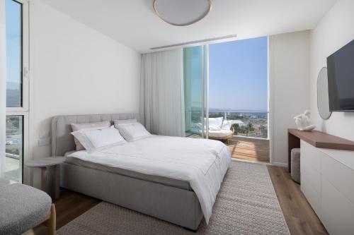 a bedroom with a bed and a large window at Penthouses 42 Residence by Brown in Eilat