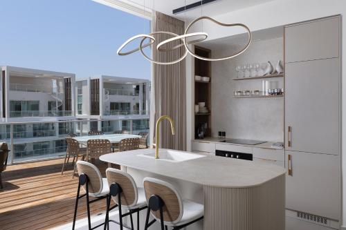 a kitchen with a table and chairs and a balcony at Penthouses 42 Residence by Brown in Eilat