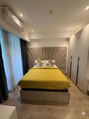 a bedroom with a large bed with a yellow blanket at Solaris in Christiansborg