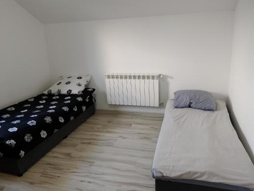 a bedroom with two beds and a radiator at Pod Lasem in Altanka