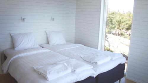 a bed with a white comforter and pillows at HavsVidden Resort in Geta