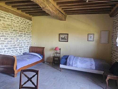 a bedroom with two beds and a brick wall at La Ferme du Mont in Foissy