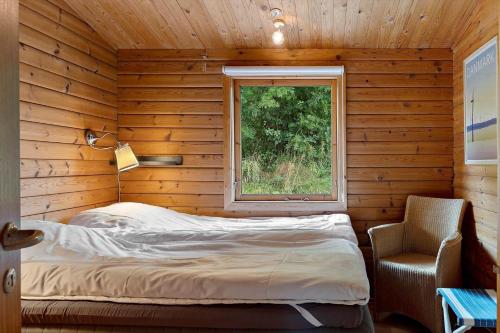 a bed in a wooden room with a window at OH456-Storvorde-Kystvej-173 in Storvorde