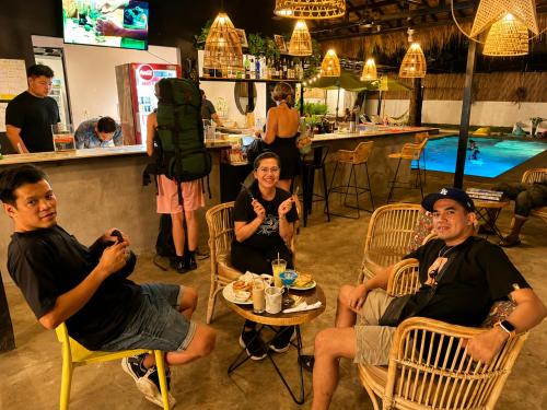 a group of people sitting in chairs in a restaurant at THE PLACE Hostel Phnom Penh in Phnom Penh