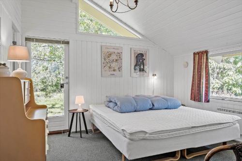 a bedroom with a bed with blue pillows on it at OH496-Hadsund-Kaeragervej-12 in Hadsund