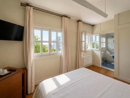 a bedroom with a bed and a large window at Las Carolinas Garden in Santander