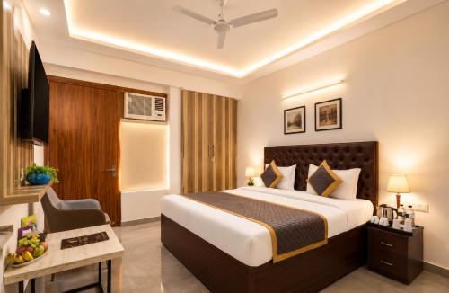 a hotel room with a bed and a television at Hotel Vibe Blue Sec 70, Near Kailash Hospital & Sec 61 -52 Metro in Noida