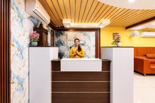 a woman standing at the counter of a waiting room at Hotel Vibe Blue Sec 70, Near Kailash Hospital & Sec 61 -52 Metro in Noida