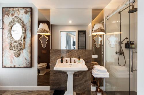 ein Badezimmer mit Waschbecken, Dusche und Spiegel in der Unterkunft Hotel Traugutta3 in Białystok