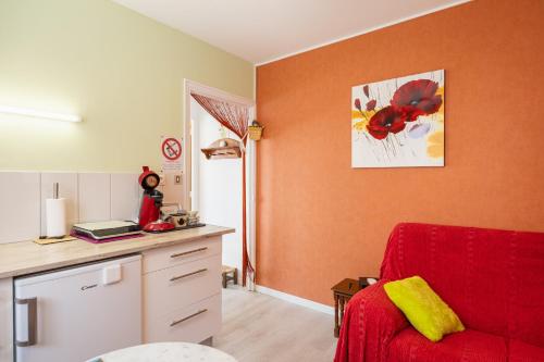 a living room with a red chair and a desk at Le Cyclamens - MC et JC in Onet le Château