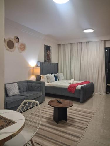 a living room with a couch and a bed at The Loftel in Ruaka