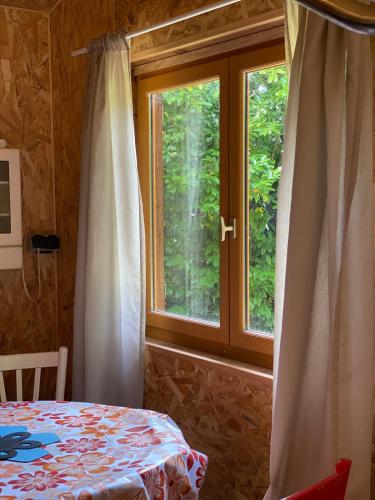 a bedroom with a bed and a window with trees at La Cabane des Bains in Marciac