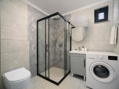 a bathroom with a shower and a washing machine at Silence garden suite iki yatak odalı daire in Alanya