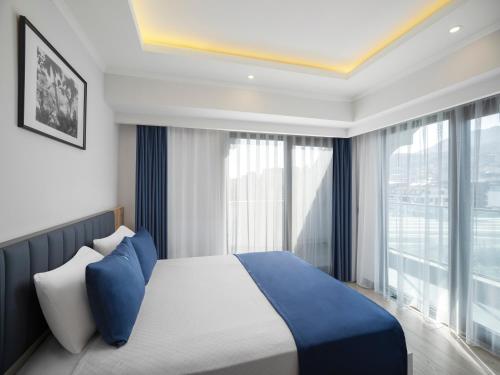 a bedroom with a bed and a large window at Silence garden suite iki yatak odalı daire in Alanya