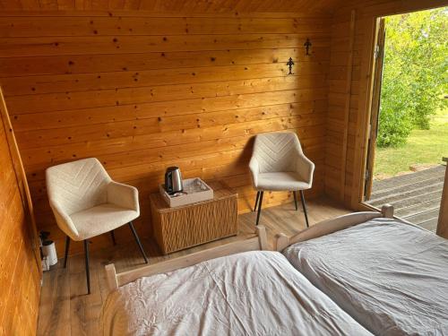 a bedroom with two chairs and a bed in a cabin at La Montagne in Tournus
