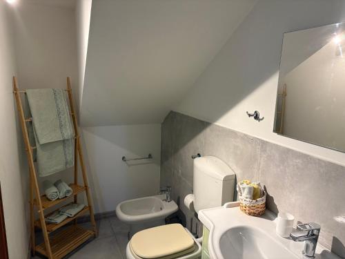 a bathroom with a white toilet and a sink at Monolocale Zefiro in Elmas
