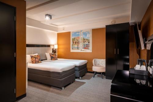a hotel room with a bed and a chair at Hotel Mansion in Amsterdam