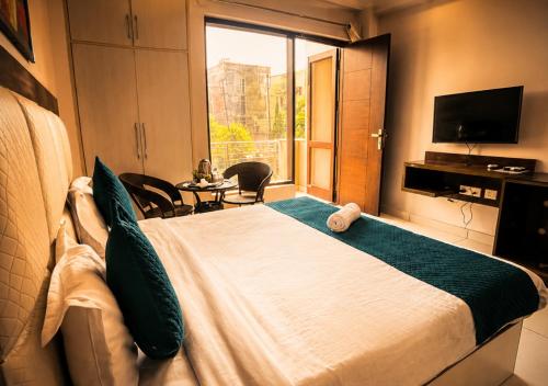 a bedroom with a large bed and a window at The Milford Noida in Noida