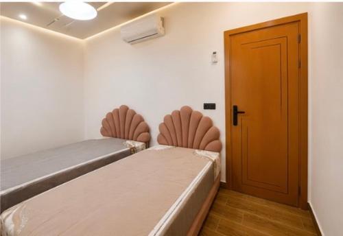 a room with a bed and a wooden door at Les 3 perles in Ras El Ma