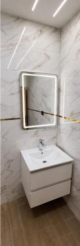 a bathroom with a white sink and a mirror at Les 3 perles in Ras El Ma