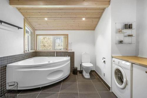a large bathroom with a tub and a toilet at HA317-Hals-Bisnapkrat-10 in Hals