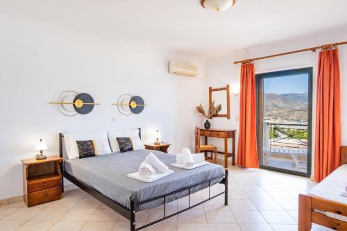 a bedroom with a bed and a large window at Fronis Studios in Karpathos