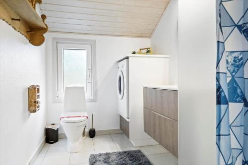 a bathroom with a toilet and a sink and a window at 0203-Romo-Peder-Jespersensvej-4 in Høm