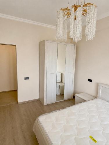 a white bedroom with a large bed and a mirror at White Residency in Yerevan