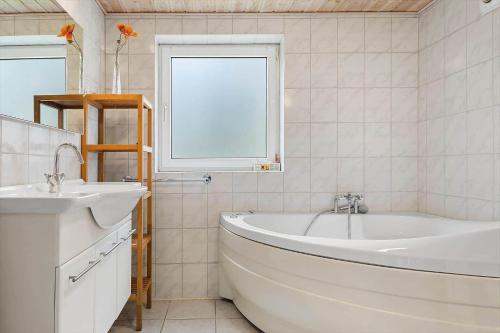 a white bathroom with a tub and a sink at 0416-Romo-Dyssebjergvej-13 in Høm