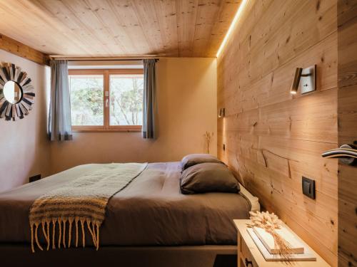 a bedroom with a bed and a wooden wall at Chalet 4★, 15 pers, La Clusaz, sauna, centre village, 7 chambres - FR-1-304-177 in La Clusaz
