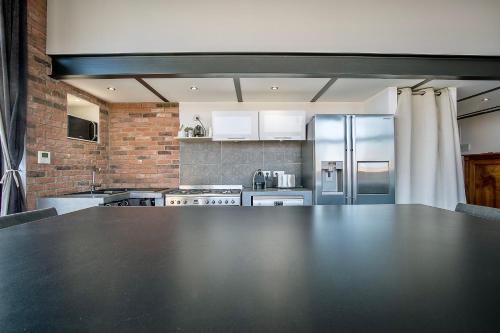 a large kitchen with a large black counter top at Le Venise Factory in Martigues
