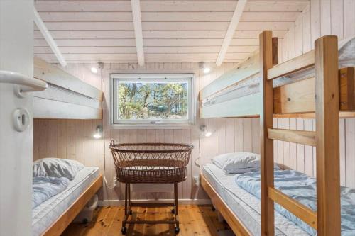 a small room with two bunk beds and a window at 0046-Romo-Trinnesvej-17 in Høm