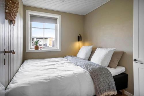 a bedroom with a white bed with a window at 381-Harboore-Slettevej-32 in Harboør