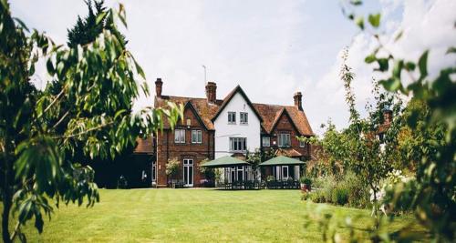 a large house with a large grassy yard at The Olde Bell, BW Signature Collection in Marlow