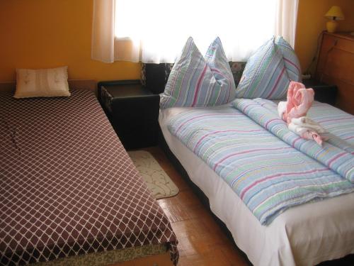 a bedroom with two beds with pillows at Keletifény Vendégház in Verpelét