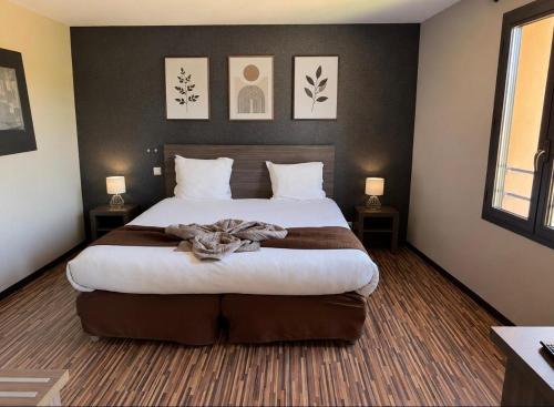 a bedroom with a large bed with two lamps at La Bourse in Bagnols-sur-Cèze