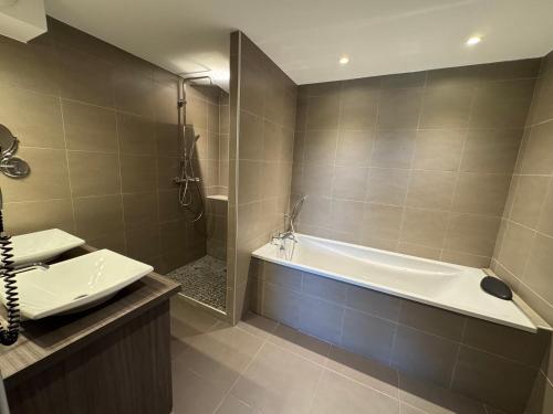 a bathroom with a bath tub and a sink at La Bourse in Bagnols-sur-Cèze