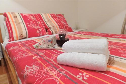 a bed with two towels and a tray with a drink at Lavender Bay Apartment C12 in Donji Morinj