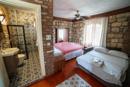 a bedroom with two beds and a bathroom at Qekik Boutique Kazdağları in Arıklı