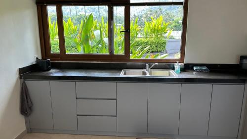 a kitchen counter with a sink and a window at Villa Lombok Surga Kedua Setangi in Mangsit