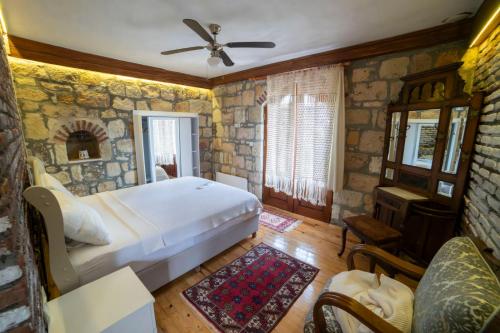 a bedroom with a bed and a stone wall at Qekik Boutique Kazdağları in Arıklı